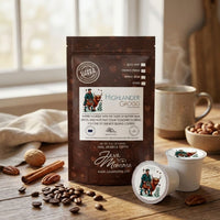Thumbnail for Highlander Grogg coffee package with coffee beans and a coffee pods on a wooden table.