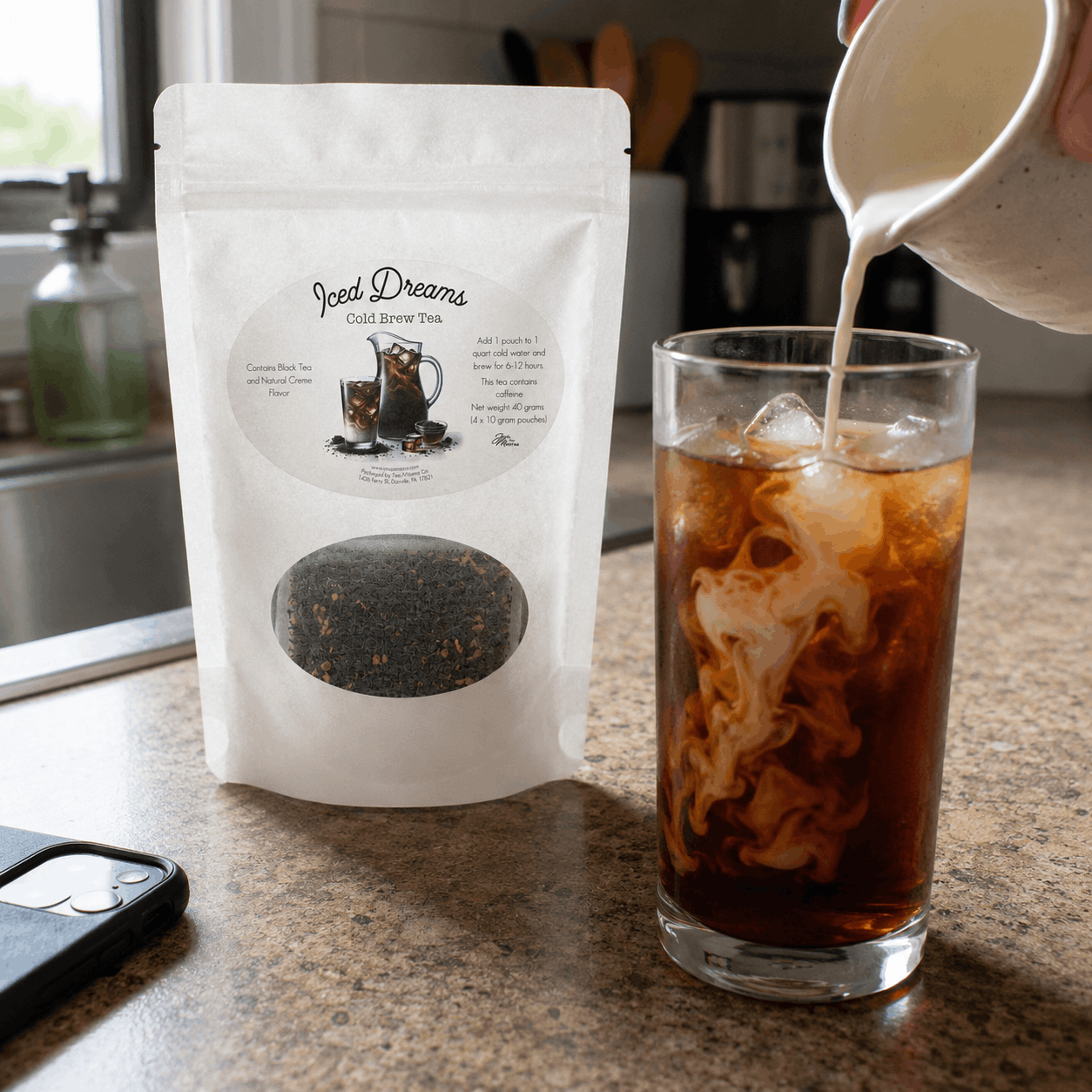Iced tea being poured into a glass next to a package of 'Iced Dreams' cold brew tea.