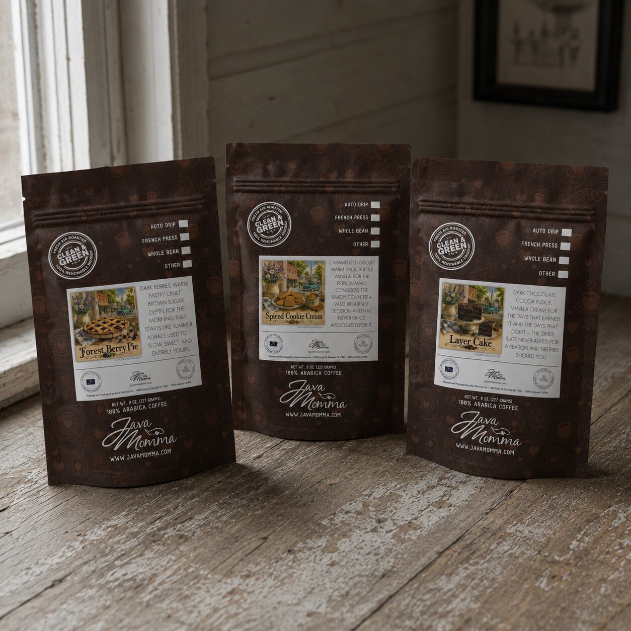 Three Java Momma coffee bags with labels on a wooden surface