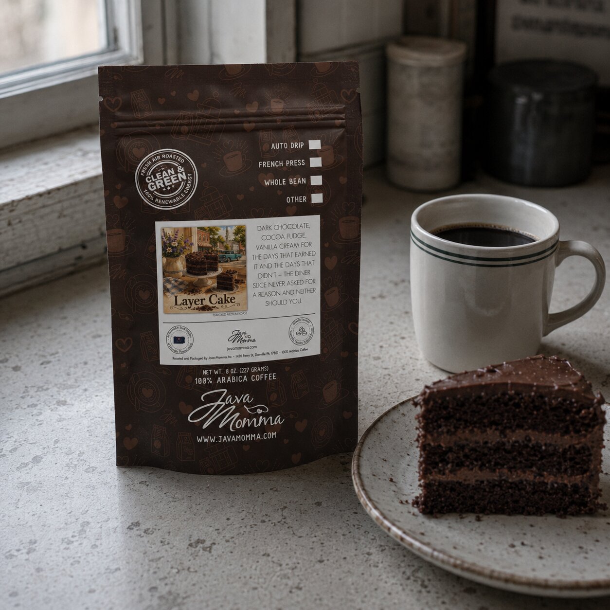 Coffee package labeled 'Java Momma' with a cup of coffee and slice of chocolate cake on a surface.