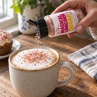 Thumbnail for Hand pouring Magical Unicorn Sugar Sprinkle onto a frothy coffee topped with colorful sprinkles.