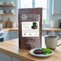 Thumbnail for Minty Thins coffee bag on a kitchen counter with steaming coffee and mint accents
