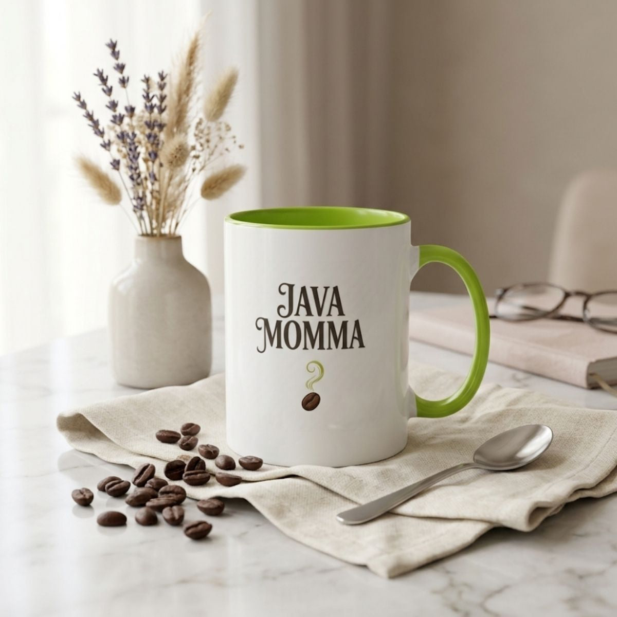 Mug with 'JAVA MOMMA' text on a marble surface with coffee beans and a spoon.