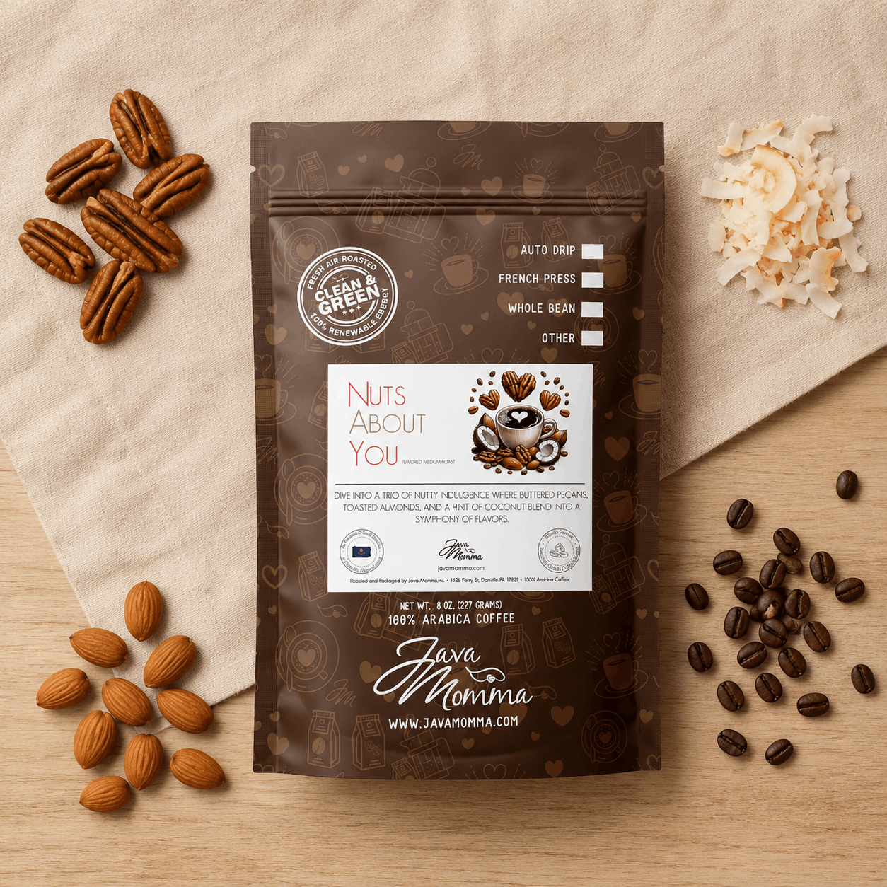 nuts about you flavored coffee bag on wooden surface and linen cloth with small piles of roasted pecans, almonds, coconut and coffee beans
