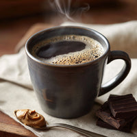 Thumbnail for Close-up of coffee mug with peanut butter spoon and chocolate pieces nearby