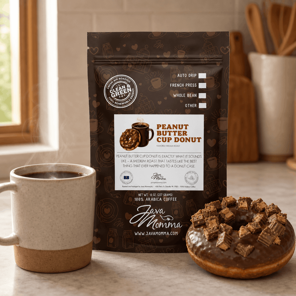 Peanut Butter Cup Donut coffee bag next to a ceramic mug with a chocolate glazed donut topped with peanut butter cup pieces