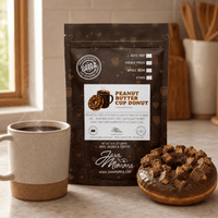Thumbnail for Peanut Butter Cup Donut coffee bag next to a ceramic mug with a chocolate glazed donut topped with peanut butter cup pieces