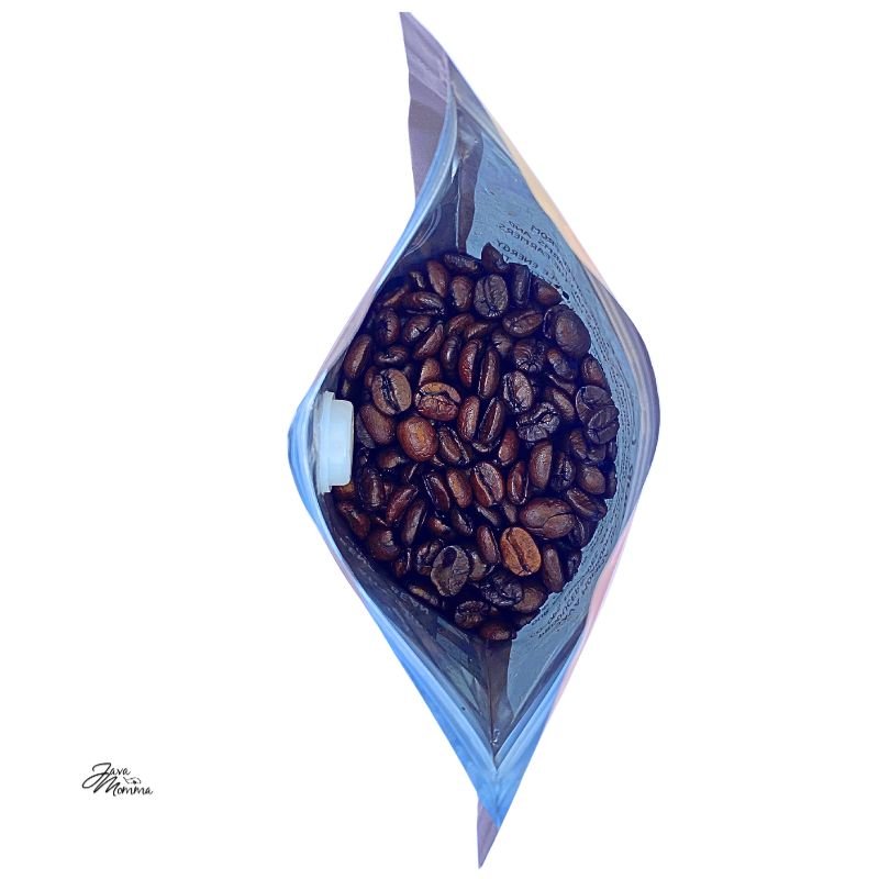 A top-down view of an open bag of Pecan Praline – Buttery, Nutty Medium Roast Inspired by a Southern Summer Treat 🥜 coffee beans, with the bag’s sides slightly folded outward on a white background.