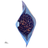Thumbnail for A top-down view of an open bag of Pecan Praline – Buttery, Nutty Medium Roast Inspired by a Southern Summer Treat 🥜 coffee beans, with the bag’s sides slightly folded outward on a white background.