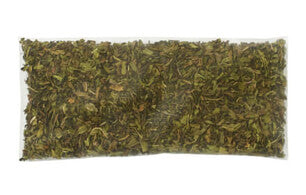 A clear plastic bag of Mint Condition Refreshing Peppermint Cold Brew Tea, filled with dried, crushed green herbs—ideal for making invigorating peppermint herbal tea—shown from above on a white background.