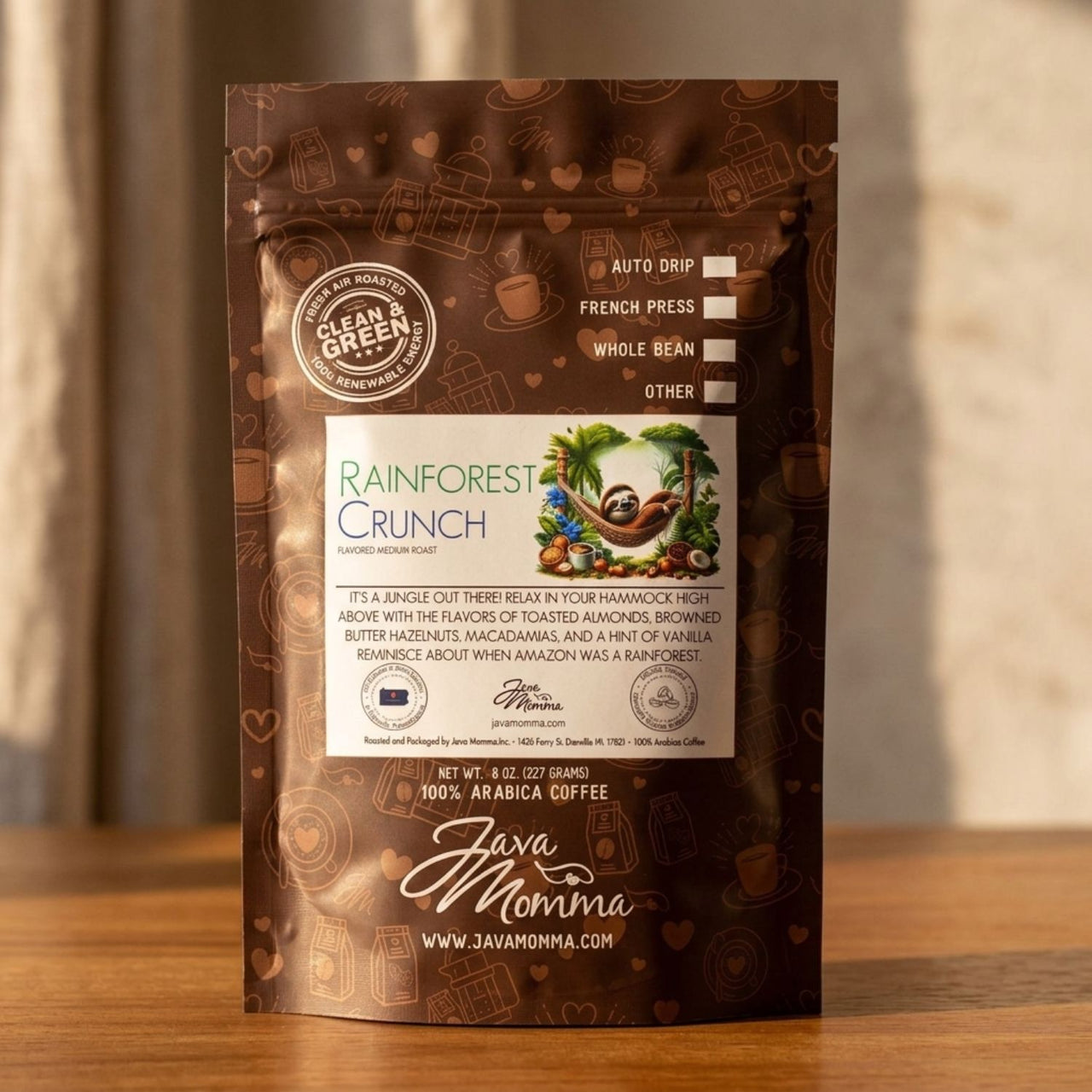 Rainforest Crunch bag standing upright on a warm medium-toned wood surface. 
Background is a soft-focus linen or stone texture. Lighting is warm and directional — 
late afternoon window light.