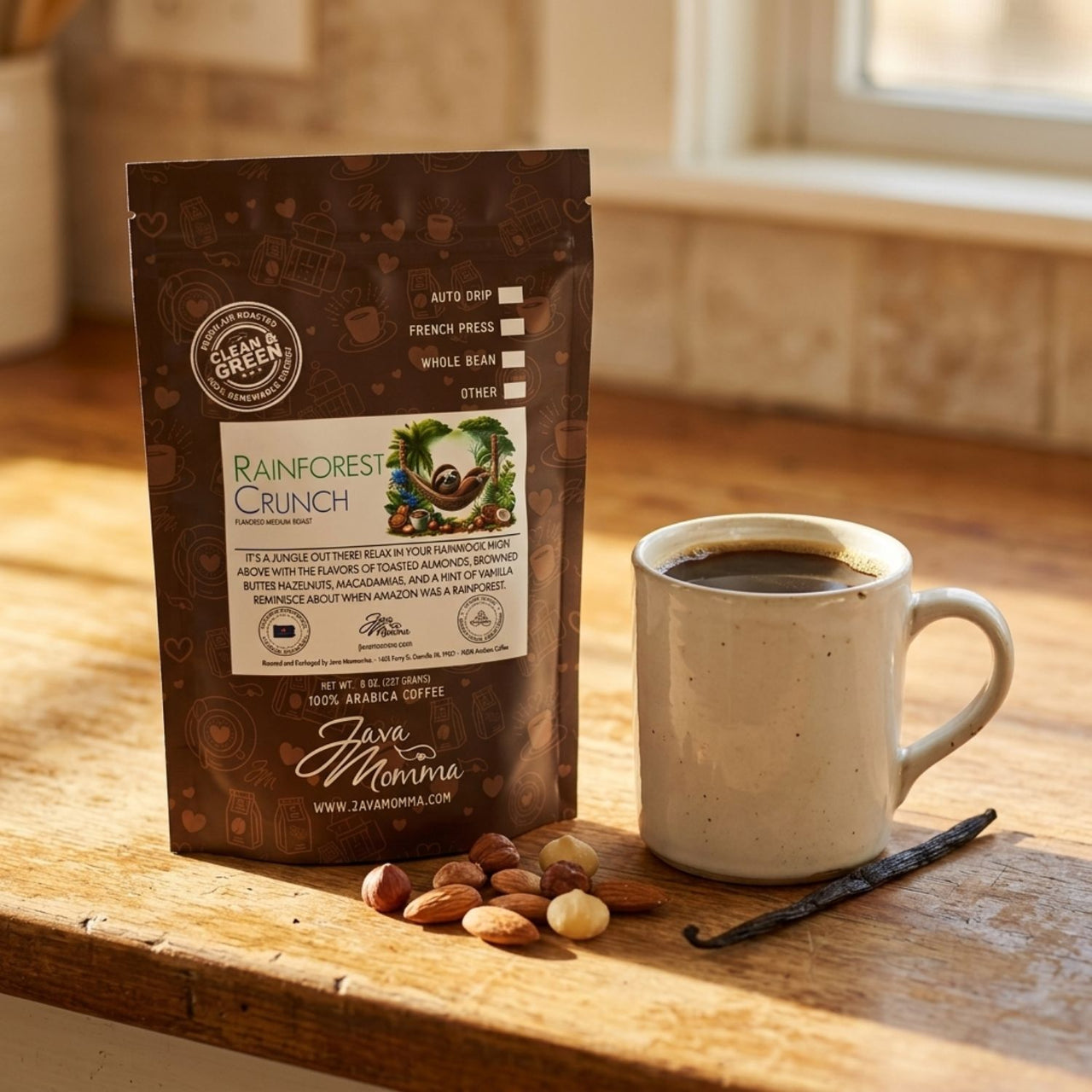 Rainforest Crunch bag on a worn wood countertop beside a ceramic mug filled 
with coffee. Scatter a small handful of raw almonds, hazelnuts, and macadamia nuts nearby. 
One vanilla bean pod resting at the base of the mug. Warm morning-to-afternoon light. 
Cozy, lived-in kitchen feel.