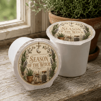Thumbnail for Season of the Witch Flavored Coffee packaging with herbs in cozy kitchen setting.