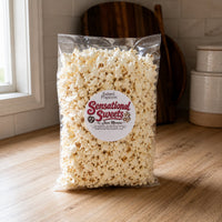 Thumbnail for Bag of Sensational Sweets salted popcorn on a wooden surface with a kitchen background.