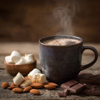 Thumbnail for Close-up of coffee mug with marshmallows and chocolate pieces nearby on a wooden surface