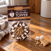 Thumbnail for Melville Cocoa Latté Marshmallow Topper Campfire S'more in a clear bag with the branded header card, photographed on a wooden table with a graham cracker and marshmallow nearby.