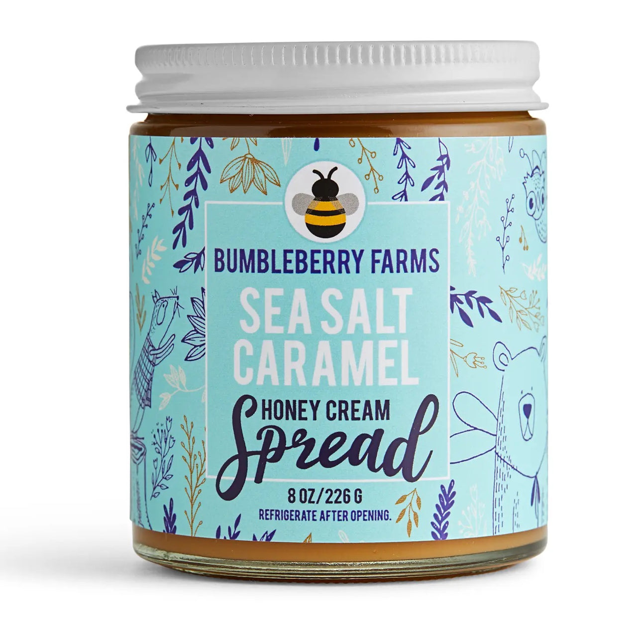 An 8 oz jar of Sea Salt 🧂 Caramel Honey Cream Spread – Sweet, Salty, & Sinfully Smooth, with a blue label featuring playful animal and floral designs, made with rich Wildflower Honey for a decadent treat.