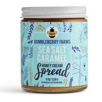 Thumbnail for An 8 oz jar of Sea Salt 🧂 Caramel Honey Cream Spread – Sweet, Salty, & Sinfully Smooth, with a blue label featuring playful animal and floral designs, made with rich Wildflower Honey for a decadent treat.