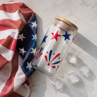 Thumbnail for Glass jar with star design next to an American flag and ice cubes on a light surface