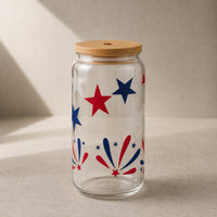 Thumbnail for Clear glass jar with wooden lid featuring red and blue star and firework design on a beige background