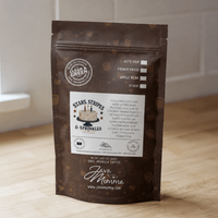 Thumbnail for Stars, Stripes & Sprinkles flavored medium roast coffee bag standing upright on a light wood floor against a white wall, natural window light.