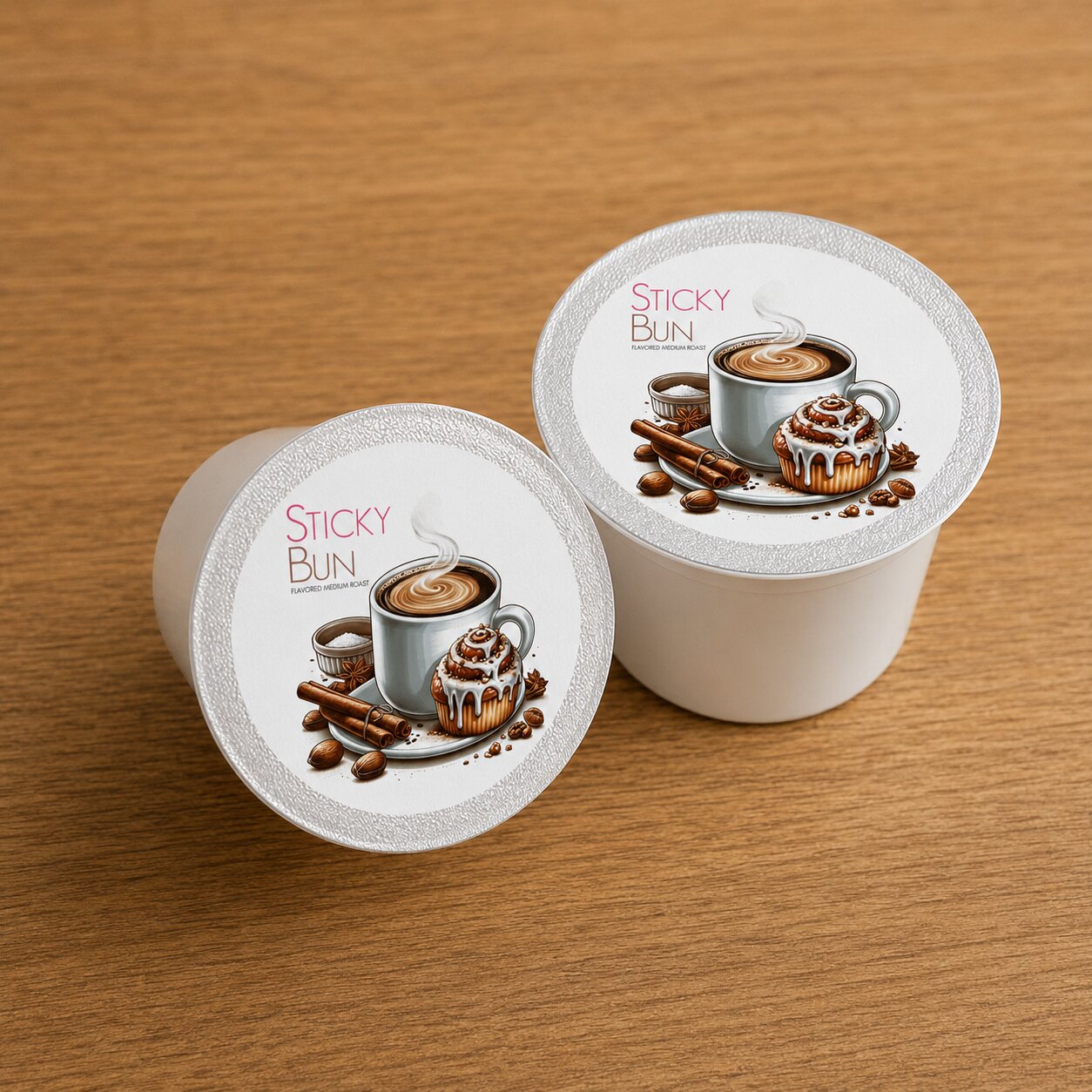 Two coffee pods with 'Sticky Bun' branding on a wooden surface