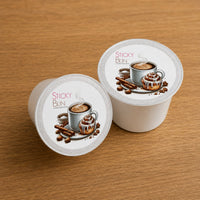 Thumbnail for Two coffee pods with 'Sticky Bun' branding on a wooden surface