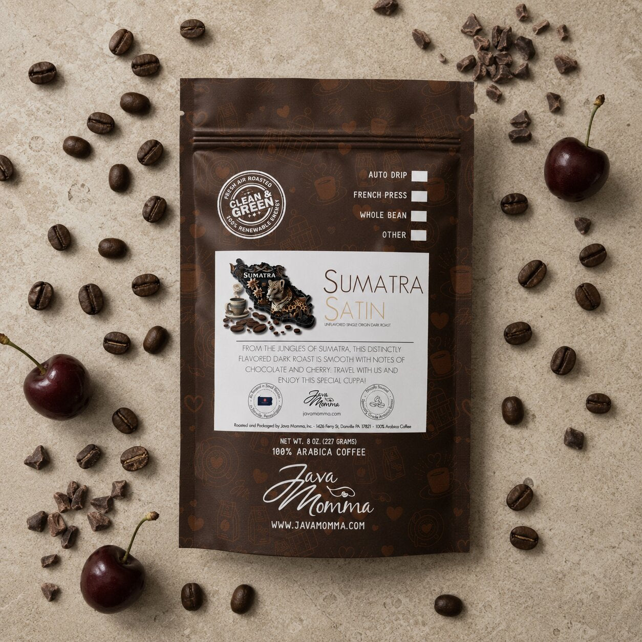 Overhead flatlay of Java Momma Sumatra Satin Dark Roast coffee bag with whole coffee beans, dark cherries, and cacao nibs