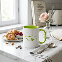 Thumbnail for White mug with green interior and handle on a marble surface with croissants, berries, and a vase of flowers.
