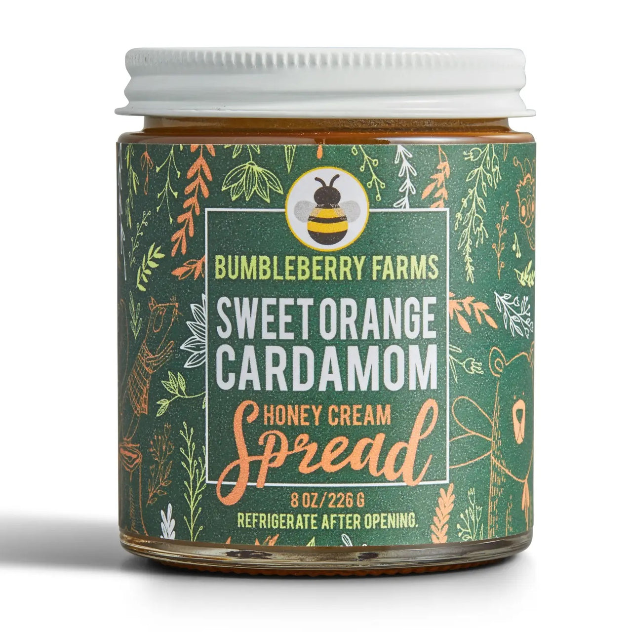 A jar of Sweet Orange Cardamom Honey Cream Spread 🍊 – Bold Citrus Meets Cozy Spice comes in an 8 oz jar with a green label featuring leaves, a bear, and a bee. Made with wildflower honey; refrigerate after opening.