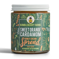 Thumbnail for A jar of Sweet Orange Cardamom Honey Cream Spread 🍊 – Bold Citrus Meets Cozy Spice comes in an 8 oz jar with a green label featuring leaves, a bear, and a bee. Made with wildflower honey; refrigerate after opening.