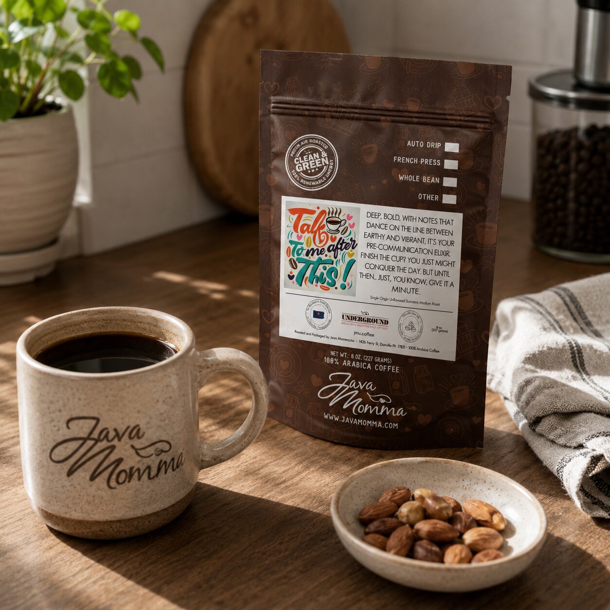 Java Momma Talk to Me After This coffee bag next to a mug of coffee with a small dish of toasted almonds