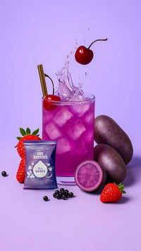 Thumbnail for A vibrant Ube Berries Tea Drop – Juicy, Antioxidant-Packed Purple Power 💜🍓🍒 with ice and a cherry garnish is pictured beside strawberries, ube yams, and berries, plus a “Ube Berries” packet on a light purple background. Caffeine-free!.