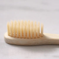 Thumbnail for Close-up of the Bamboo Toothbrush – Eco-Friendly, Biodegradable Handle & Medium Bristles, shown on a light-colored surface.