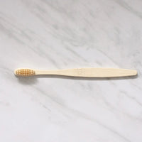 Thumbnail for The Bamboo Toothbrush – Eco-Friendly, Biodegradable Handle & Medium Bristles rests flat on a white marble surface.
