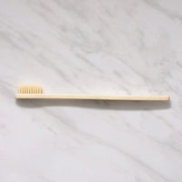 Thumbnail for The Bamboo Toothbrush – Eco-Friendly, Biodegradable Handle & Medium Bristles rests flat on a white marble surface.