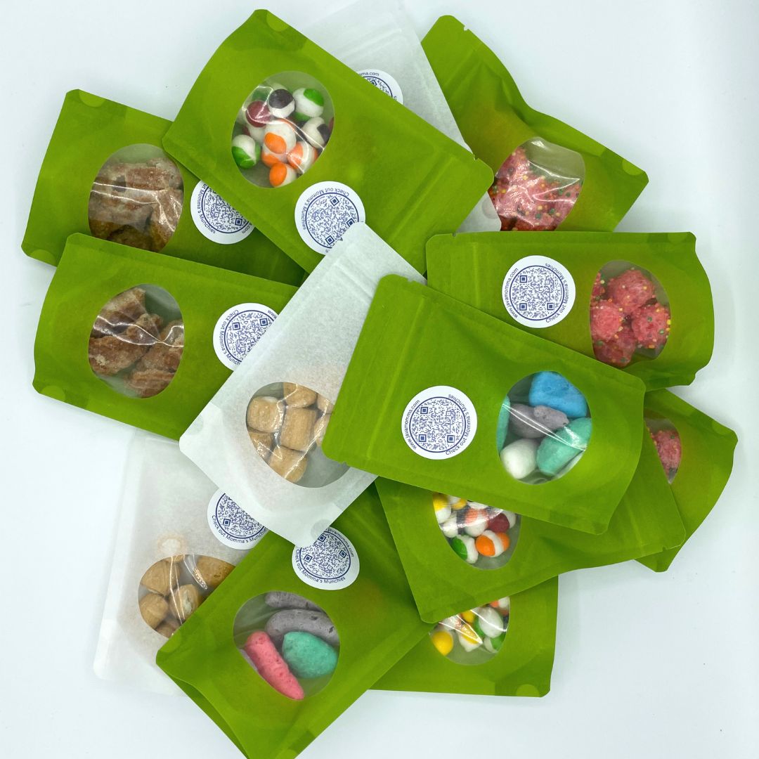 A pile of 🎃 Spooky Snack Attack – Freeze-Dried Halloween Treat Sampler 👻 packs, each with a clear window revealing assorted candies and a round white label—perfect for fans of limited edition or freeze-dried Halloween treats.
