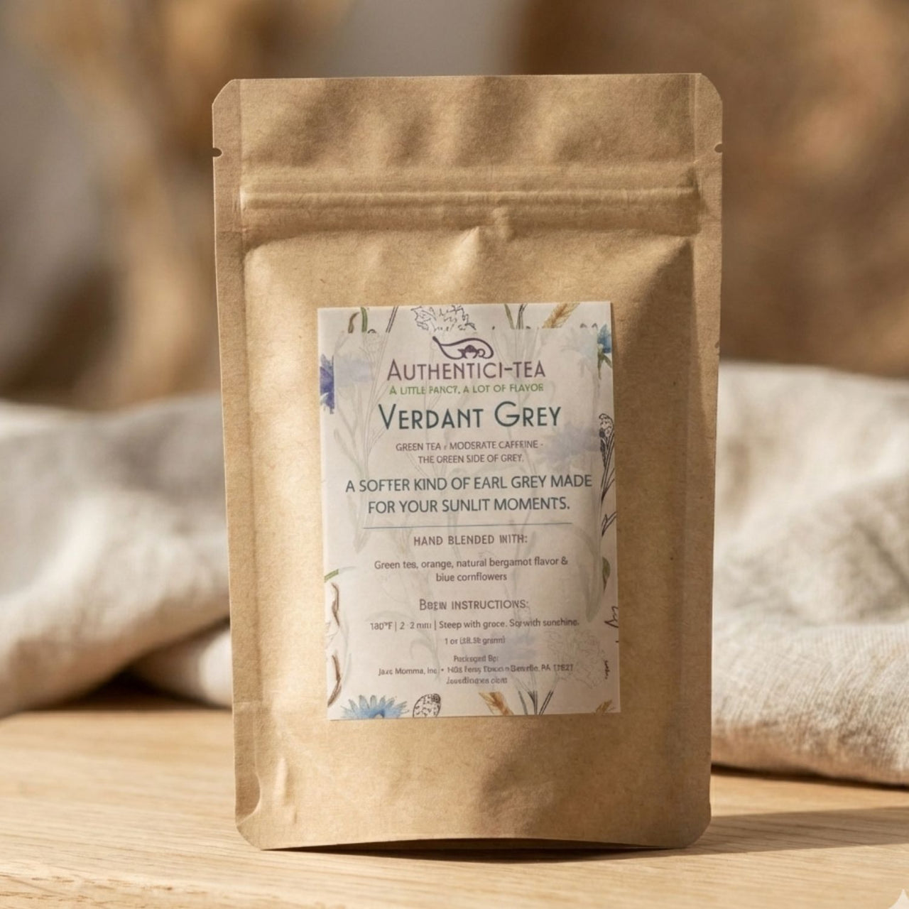 Tea package labeled 'Verdant Grey' on a wooden surface with a blurred background