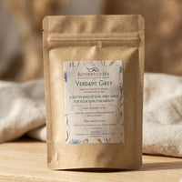 Thumbnail for Tea package labeled 'Verdant Grey' on a wooden surface with a blurred background