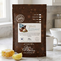 Thumbnail for Java Momma White Elephant coffee bag beside a pour-over dripper and filled ceramic mug