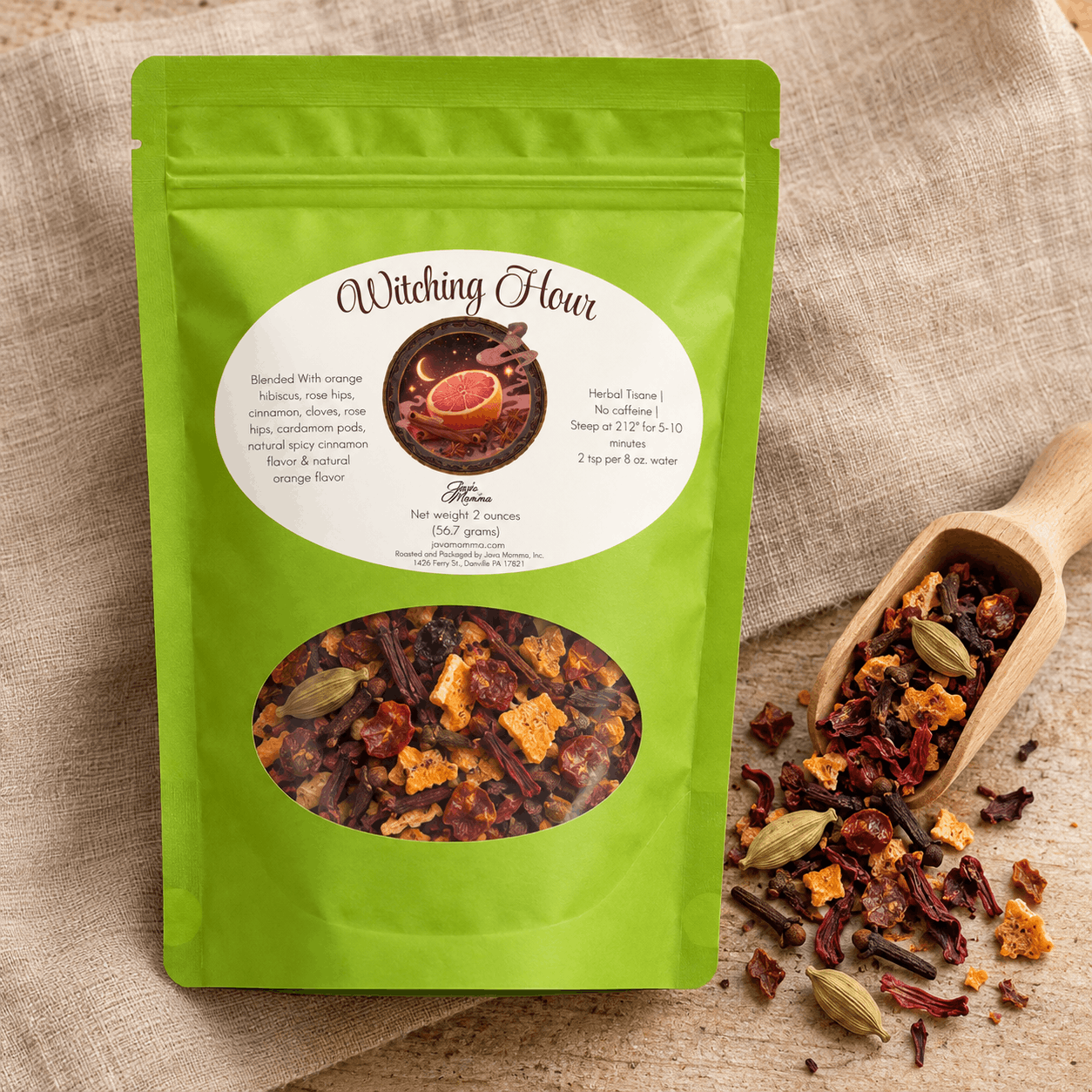 A bright green stand-up pouch labeled 'Witching Hour' tea mix, shown on a beige burlap surface with a wooden spoon and spilled loose tea pieces beside it.